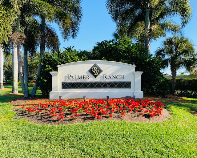 Palmer Ranch community entrance sign surrounded by palm trees and flowers in Sarasota, Florida